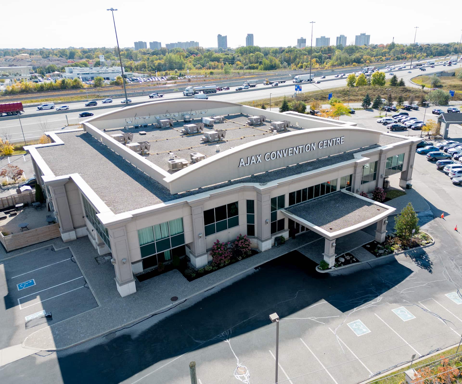 Aerial view of Ajax Convention Centre building with car park and motorway in the background.
